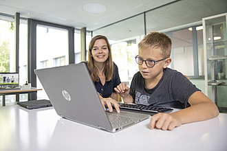 Im digitalen Schulzimmer probiert der Schüler das neuste Laptop aus.