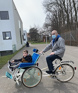 alte Fahrrad Rollstuhl mit Kind in Begleitung